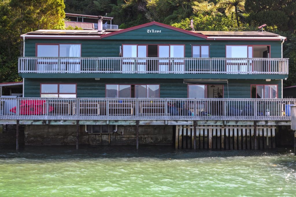 The green lodge standing over the water